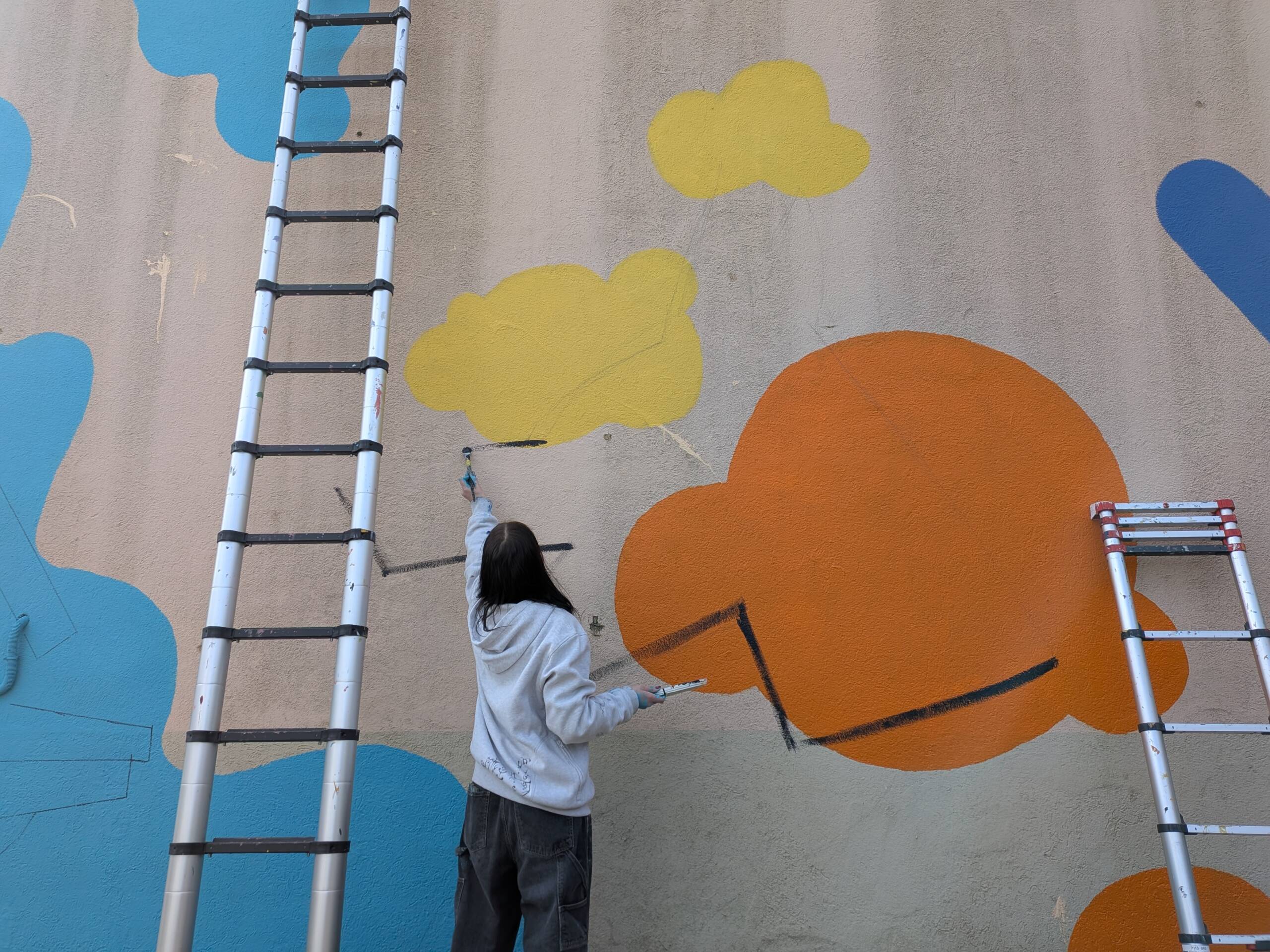Fresque murale en extérieur, pour la façade de la pension canine PawsitiveJob de l'association Solivet. Une oeuvre d'art aux forme abstraites colorées, et aux lignes noires qui reprennent le logo de Solivet : une tête de chien et des mains.