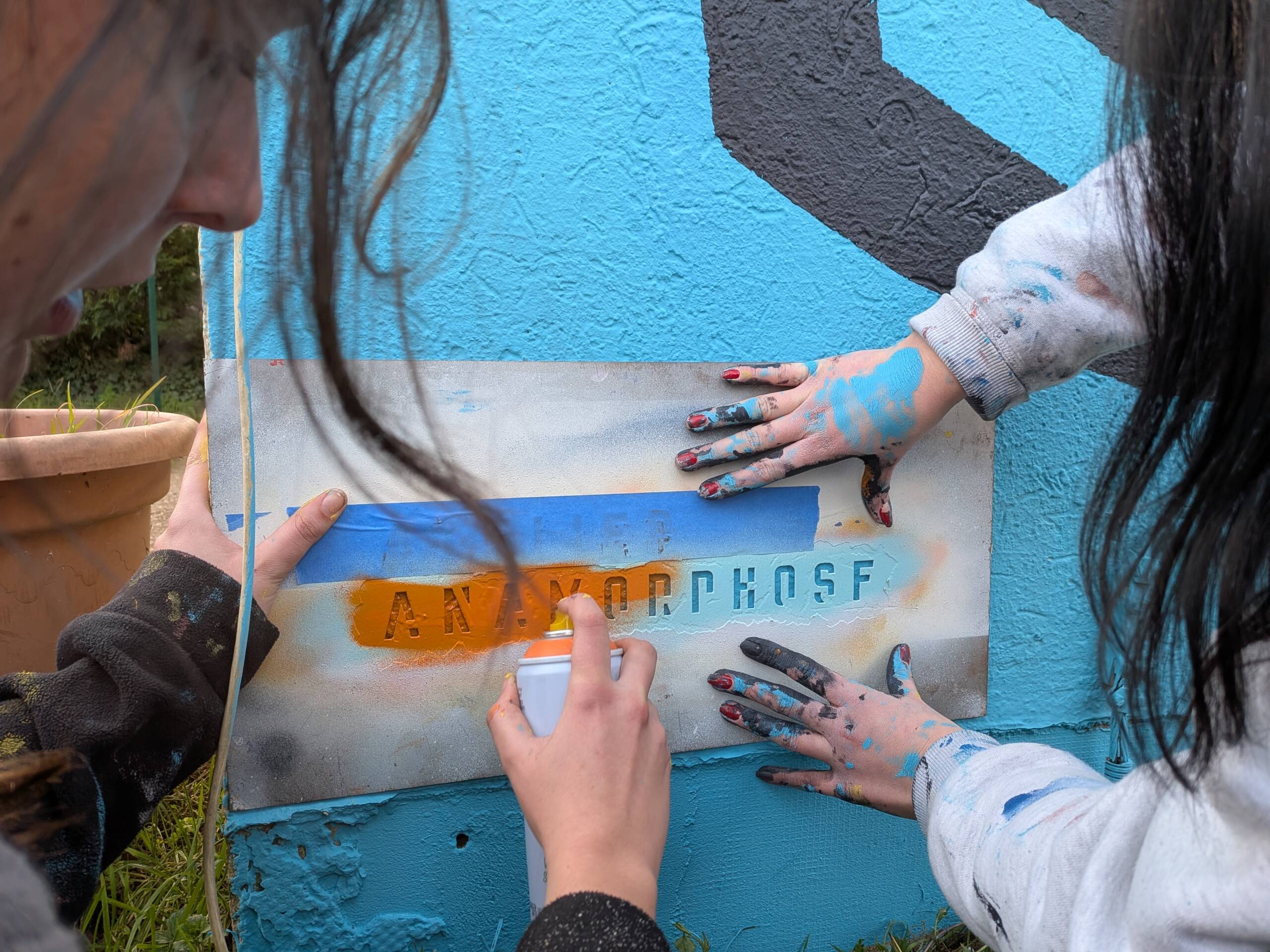 Fresque murale en extérieur, pour la façade de la pension canine PawsitiveJob de l'association Solivet. Une oeuvre d'art aux forme abstraites colorées, et aux lignes noires qui reprennent le logo de Solivet : une tête de chien et des mains.